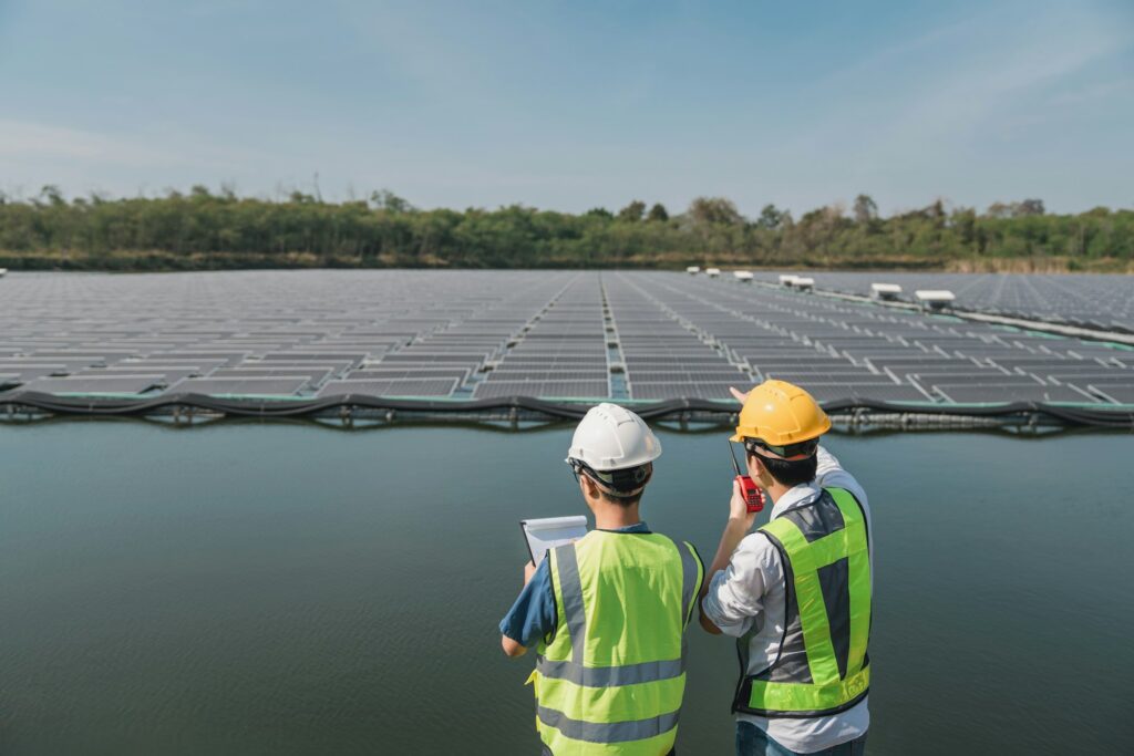 Service engineer checking solar cell on the lake. Team electrical on site floating solar panels.